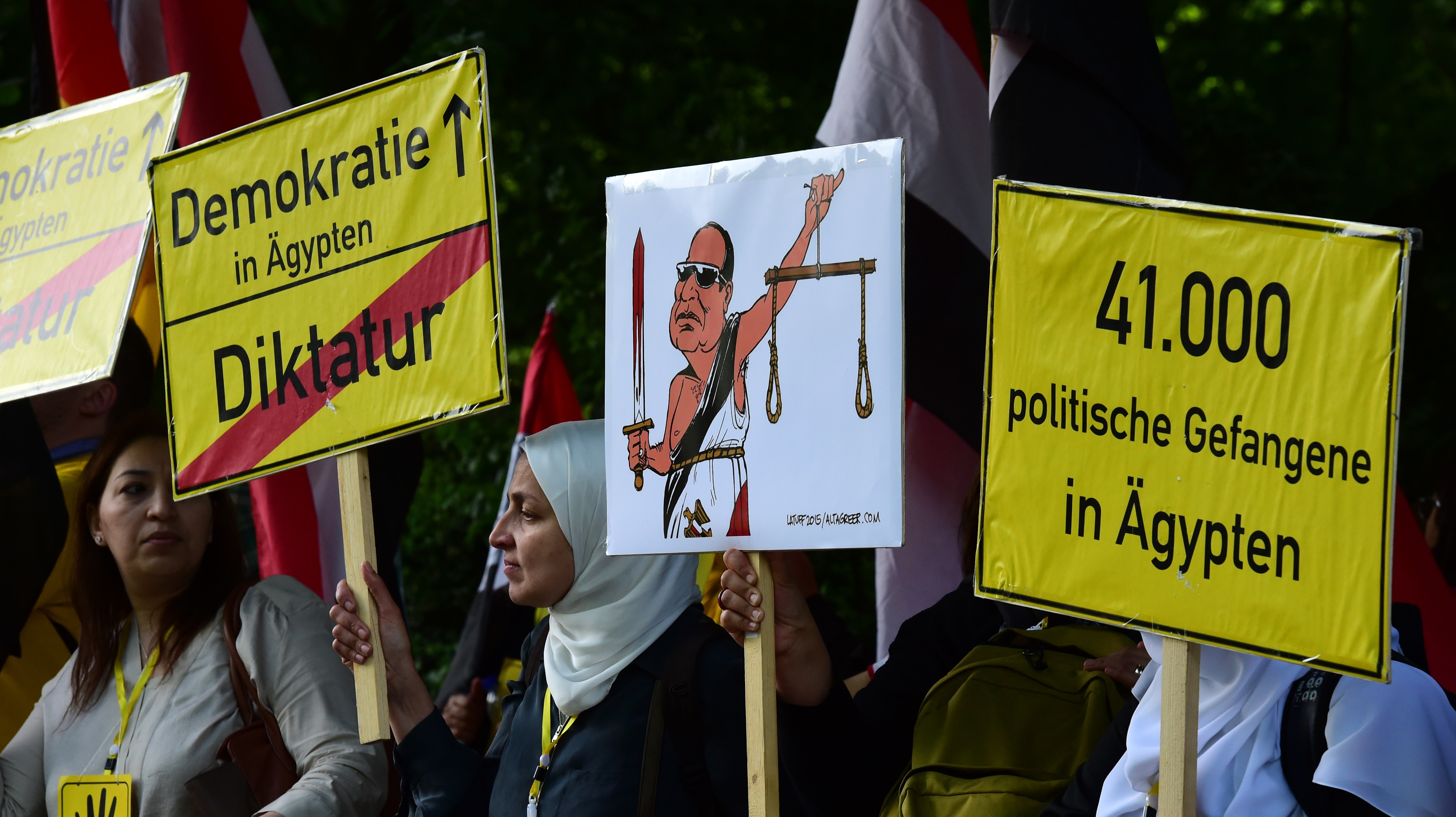 Protesters hold banners reading "Democracy in Egypt- Dictatorship" prior arrival of Egyptian President Abdel Fattah al-Sisi for the meeting with German President in front of Schloss Bellevue castle on 3 June, 2015 in Berlin (AFP)