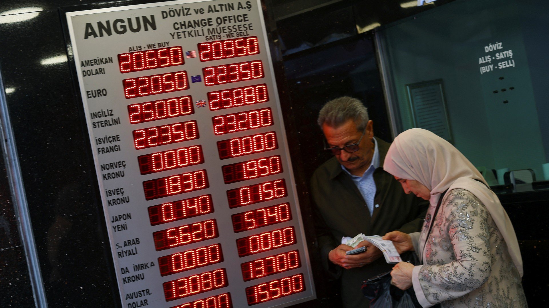 People visit a currency exchange office, after Turkish President Recep Tayyip Erdogan was declared the winner in the second round of the presidential election, in Istanbul, on 29 May (Reuters)