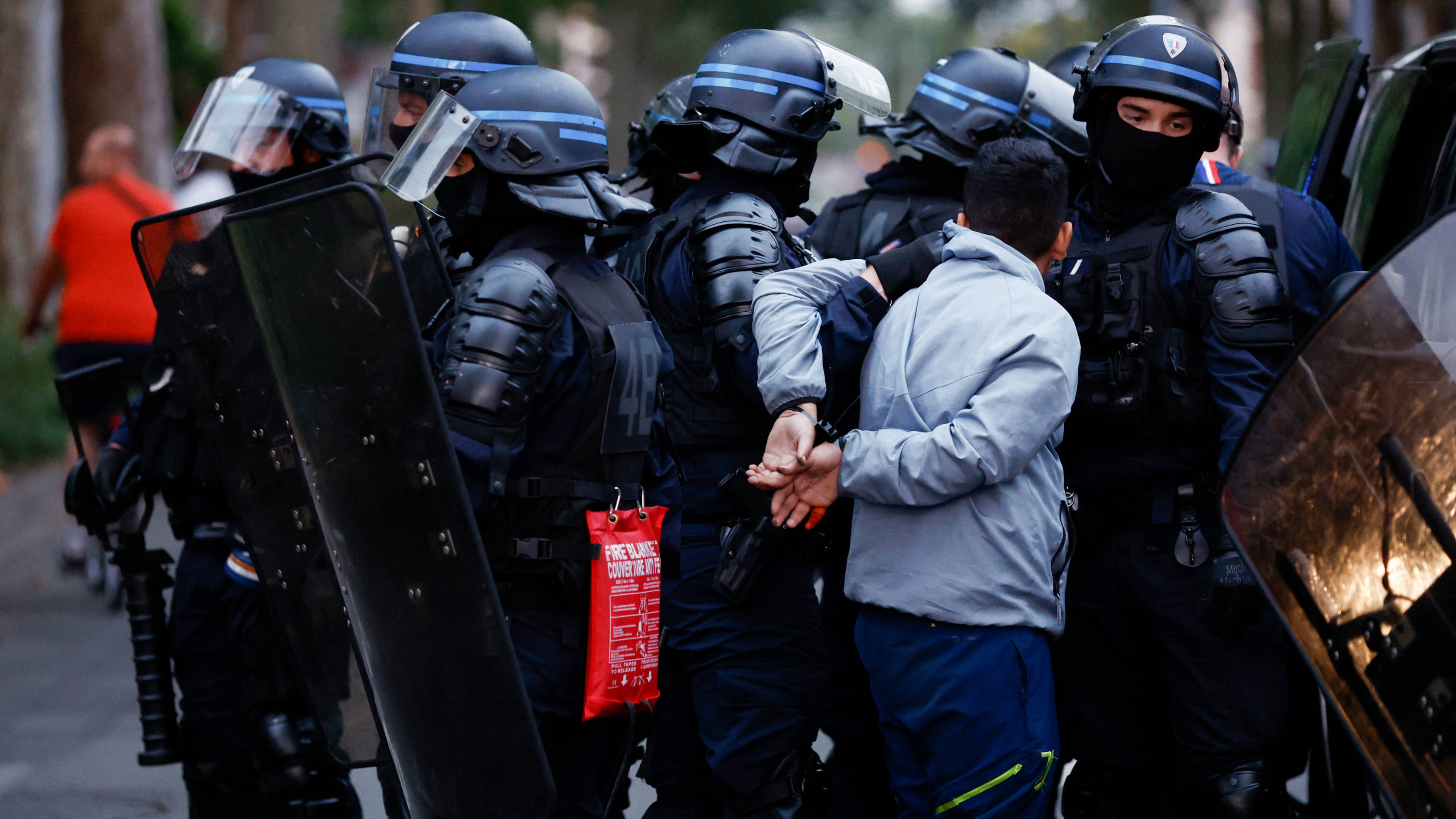 Police officers arrest a man during protests in Lille, northern France, on 29 June 2023 (AFP)