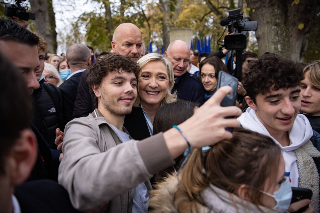 French far-right 2022 French presidential election candidate Marine Le Pen (C) poses for 'selfies' with supporters