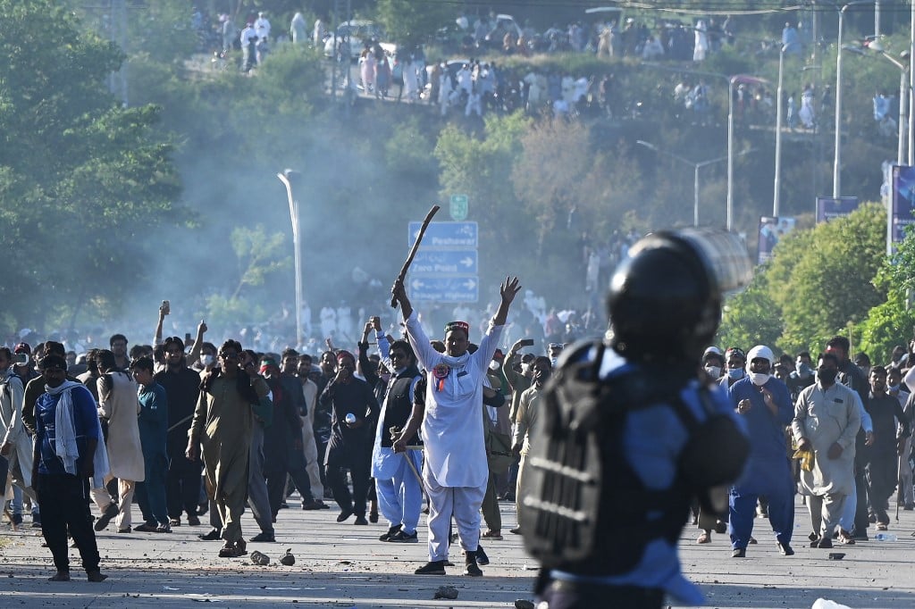 PTI party activists and supporters of Imran Khan clash with police outside the police headquarters where the former PM is being kept in custody, in Islamabad, 10 May 2023 (AFP)