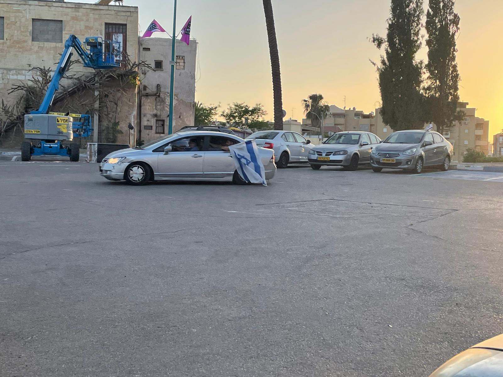 Israeli ultra-nationalists driving around Lod waving Israeli flags, on 12 May, 2021 (MEE/Lubna Marsawa)