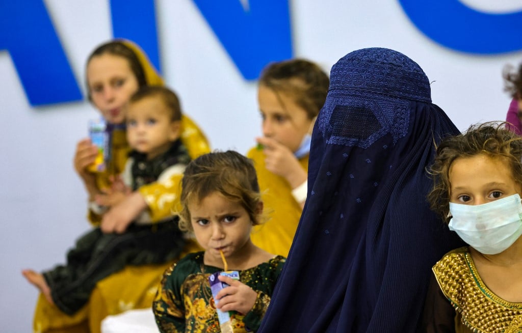 Refugees who fled Afghanistan after the takeover of their country by the Taliban, gather at the International Humanitarian City (IHC) in the Emirati capital Abu Dhabi, as they wait to be transferred to another destination, on August 28, 2021.
