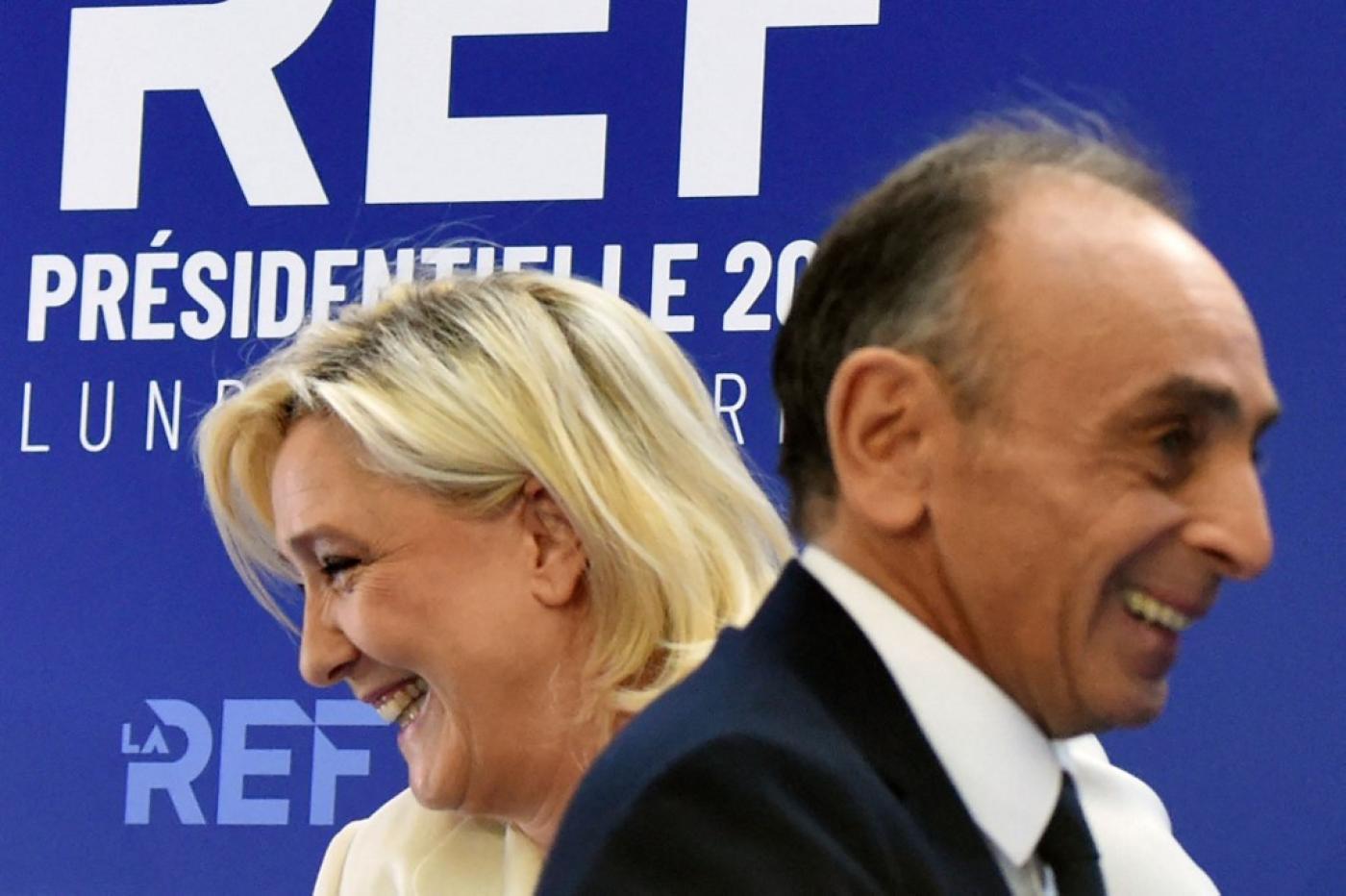 French presidential candidates Eric Zemmour and Marine Le Pen pass each other in Paris on 21 February 2022 (AFP)