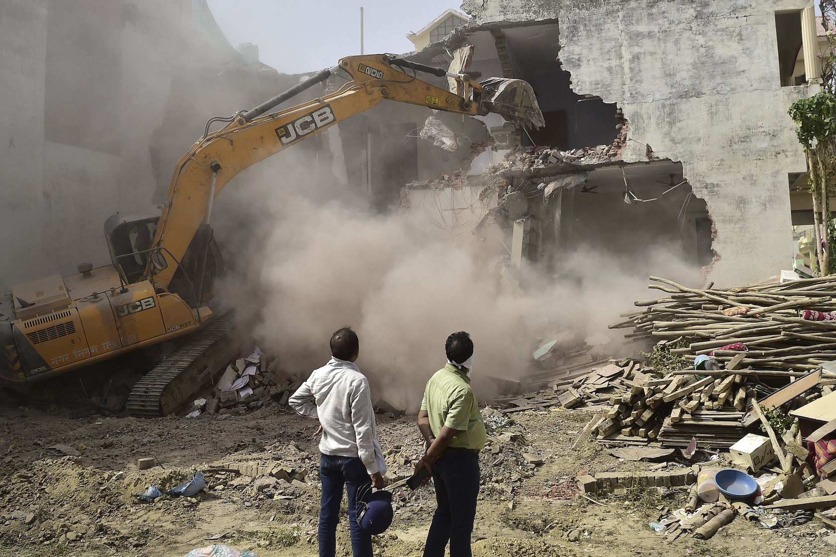 A bulldozer demolishes the house of Javed Mohammad in India after authorities accused him of taking part in protests in June 2022 [AFP]