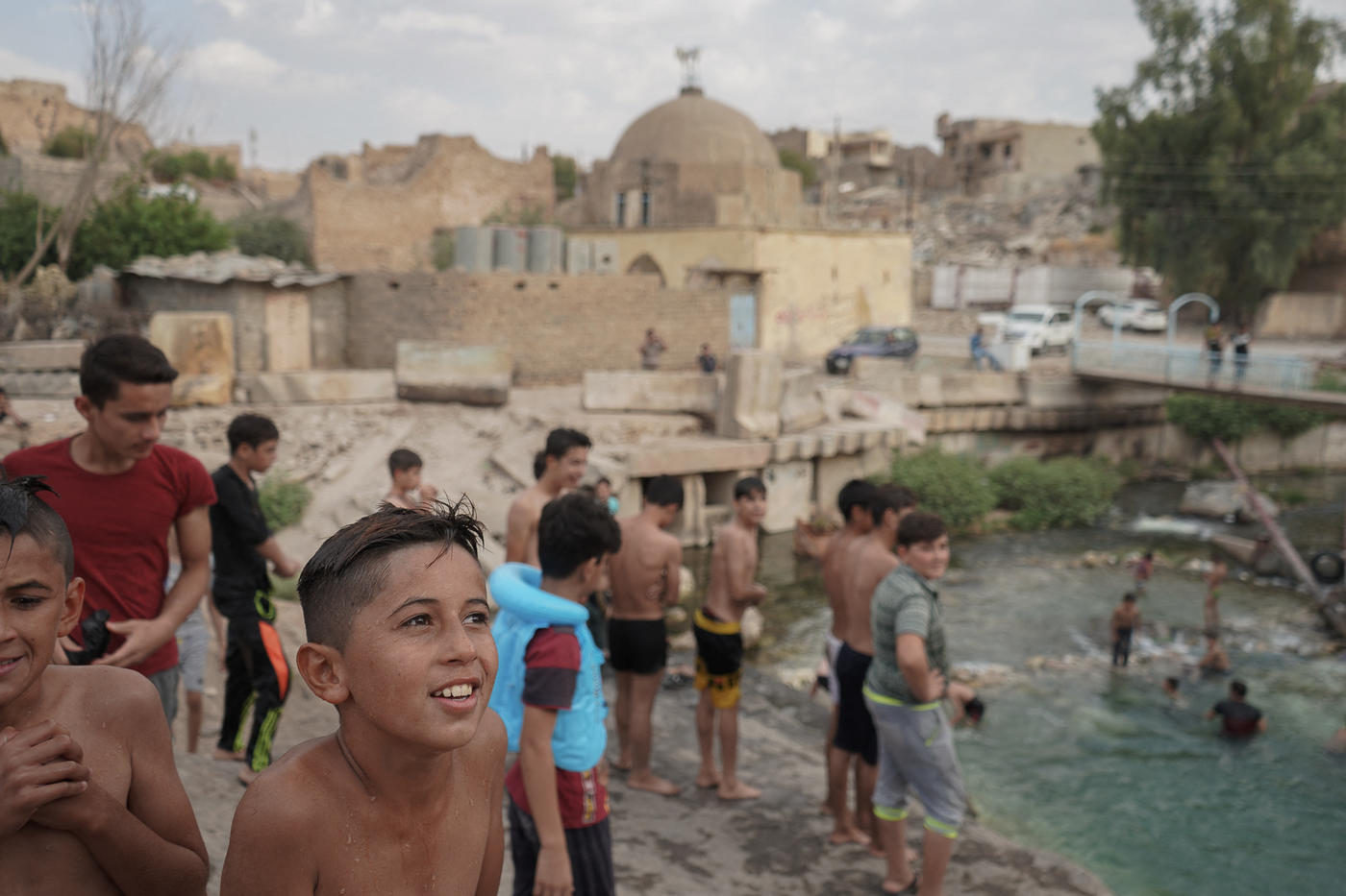 ​  Iraqi boys jumping and swimming in the river inside the devastated town of Tal Afar in September 2019 (Reuters)  ​