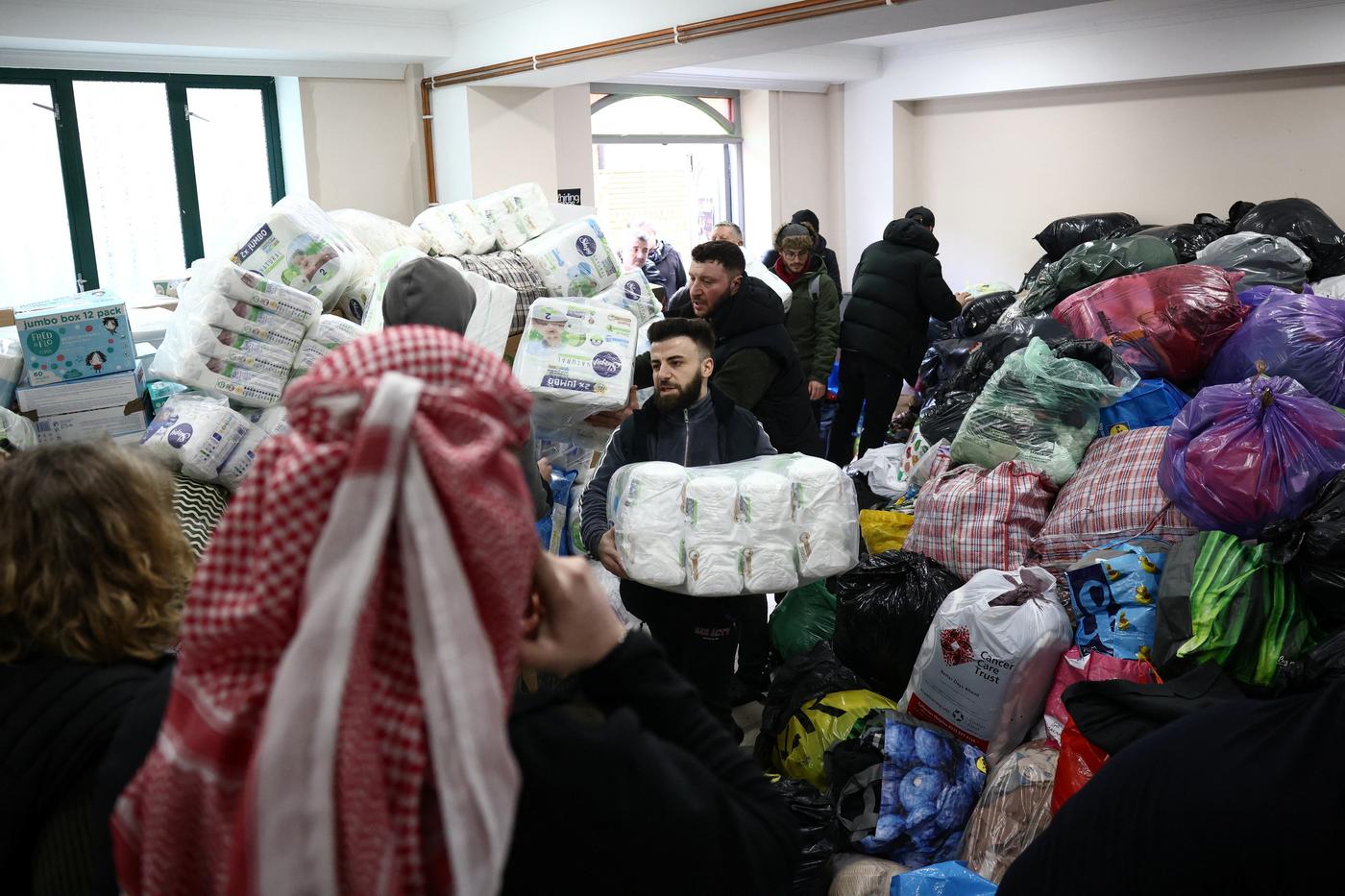 Members of the Turkish community sort donations at the Aziziye Mosque, north London as they prepare to send aid to Turkey to support victims of the earthquake (Reuters)
