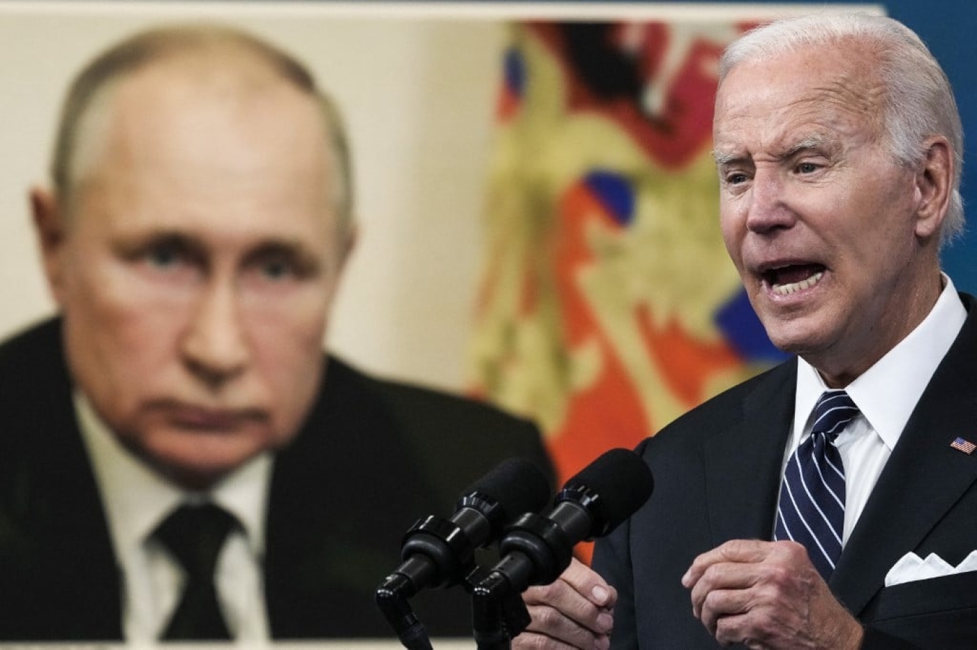 An image of Russian President Vladimir Putin behind US President Joe Biden as he speaks about gas prices at the White House on 22 June 2022 (AFP)