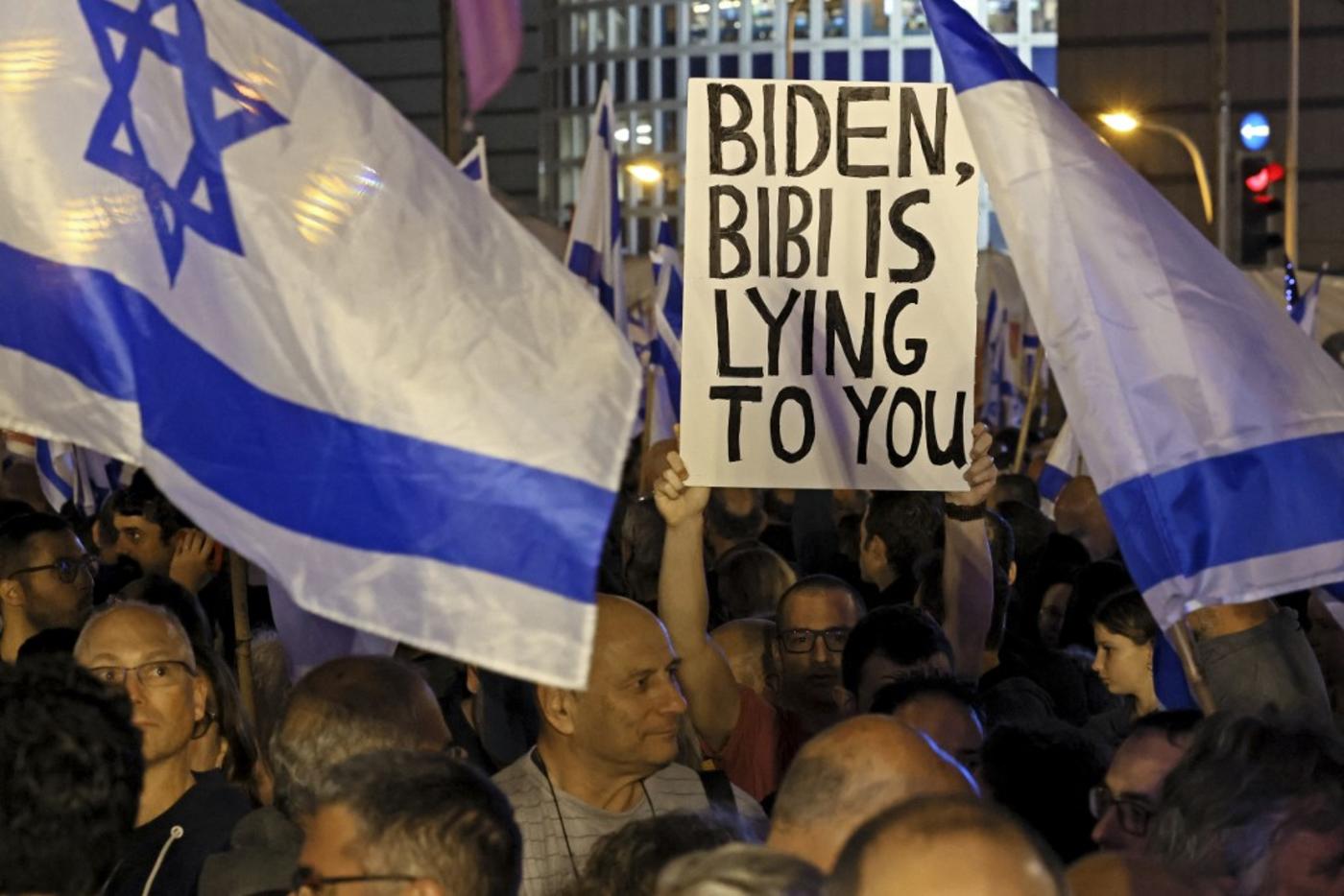 Israelis hold placards and wave flags in Tel Aviv on 28 January 2023 during a protest against controversial government plans to give lawmakers more control of the judicial system (AFP)