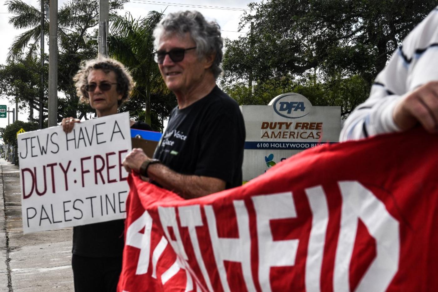 Members of Jewish Voice for Peace hold flags and placards as they protest outside the Duty Free Americas Headquarters in Hollywood, Florida on 2 June 2021.