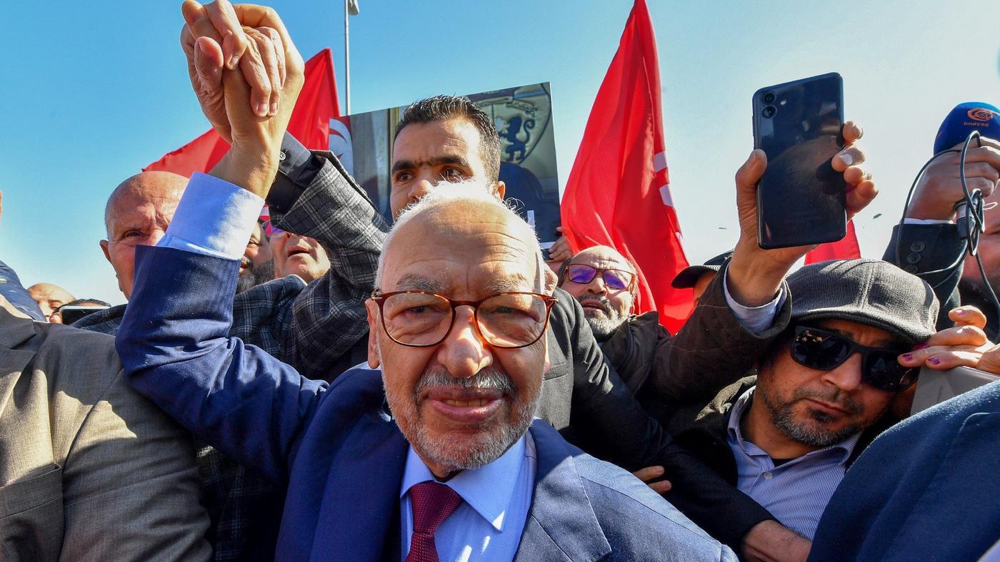 Rached Ghannouchi, leader of Tunisia's Ennahda party, greets supporters upon arrival to a police station in Tunis, on 21 February 2023 (AFP)