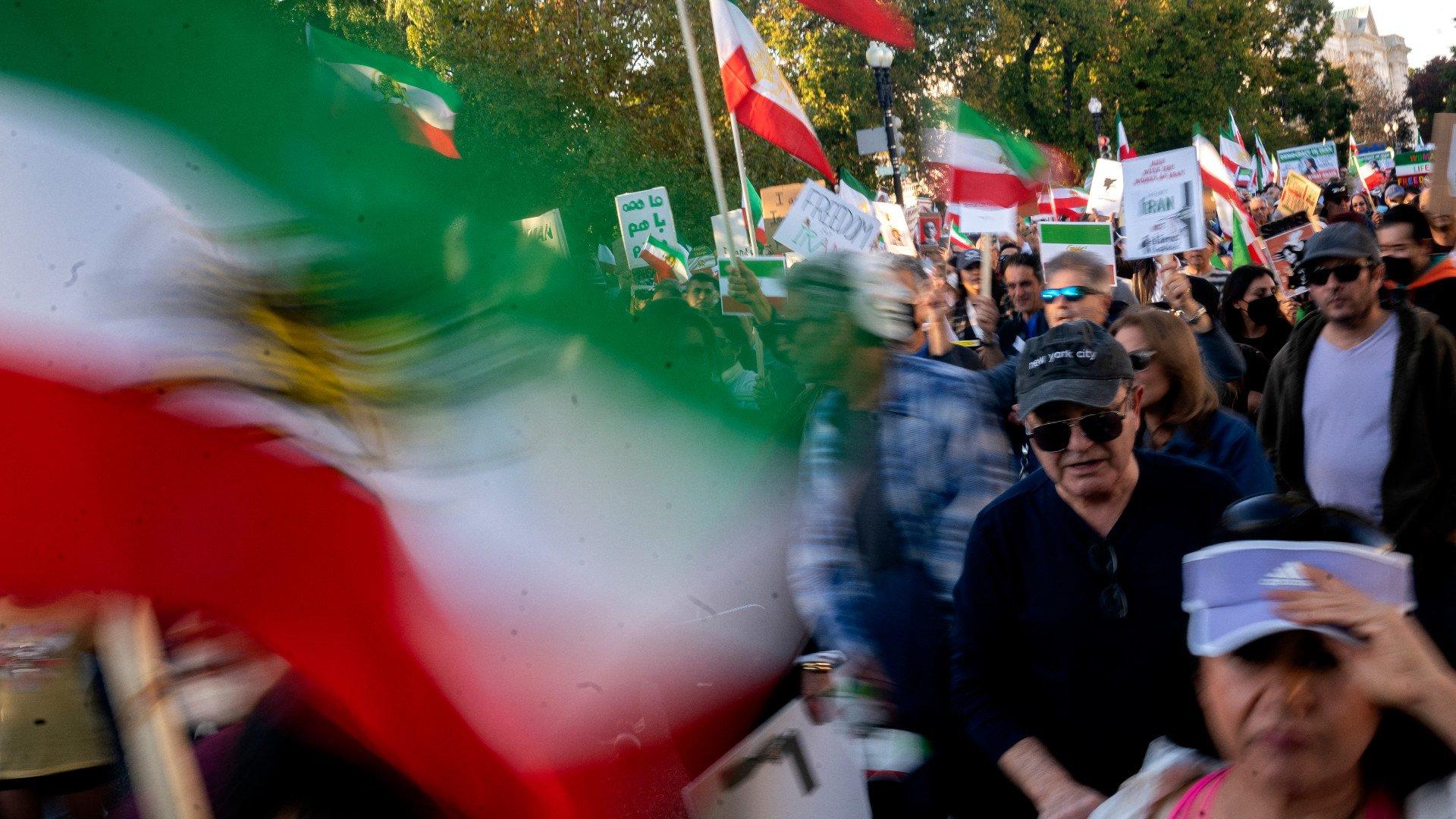 Demonstrators chant slogans and carry Iranian flags while marching during the "March of Solidarity for Iran" in Washington, DC, on 15 October, 2022 (AFP)