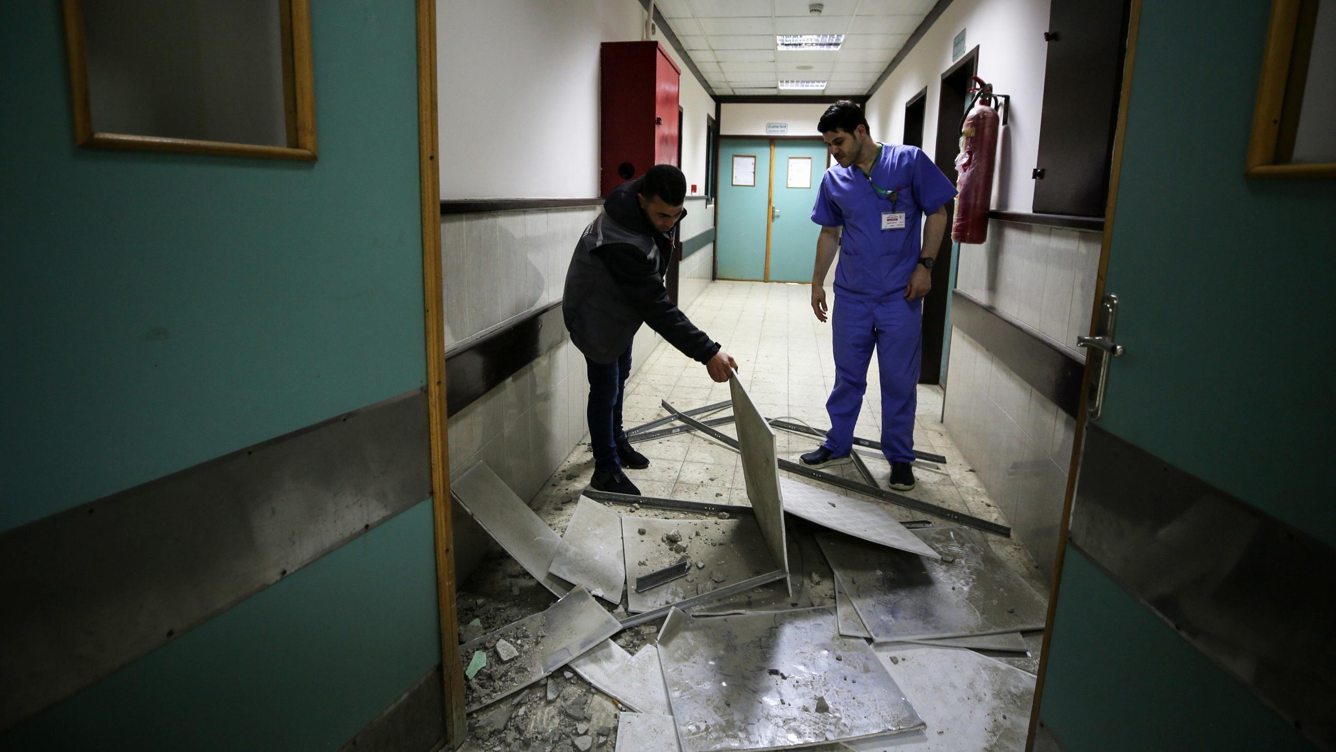 A doctor inspect a hospital damaged in a nearby Israeli strike, in the central Gaza Strip 13 May 2023 (NurPhoto via Reuters)