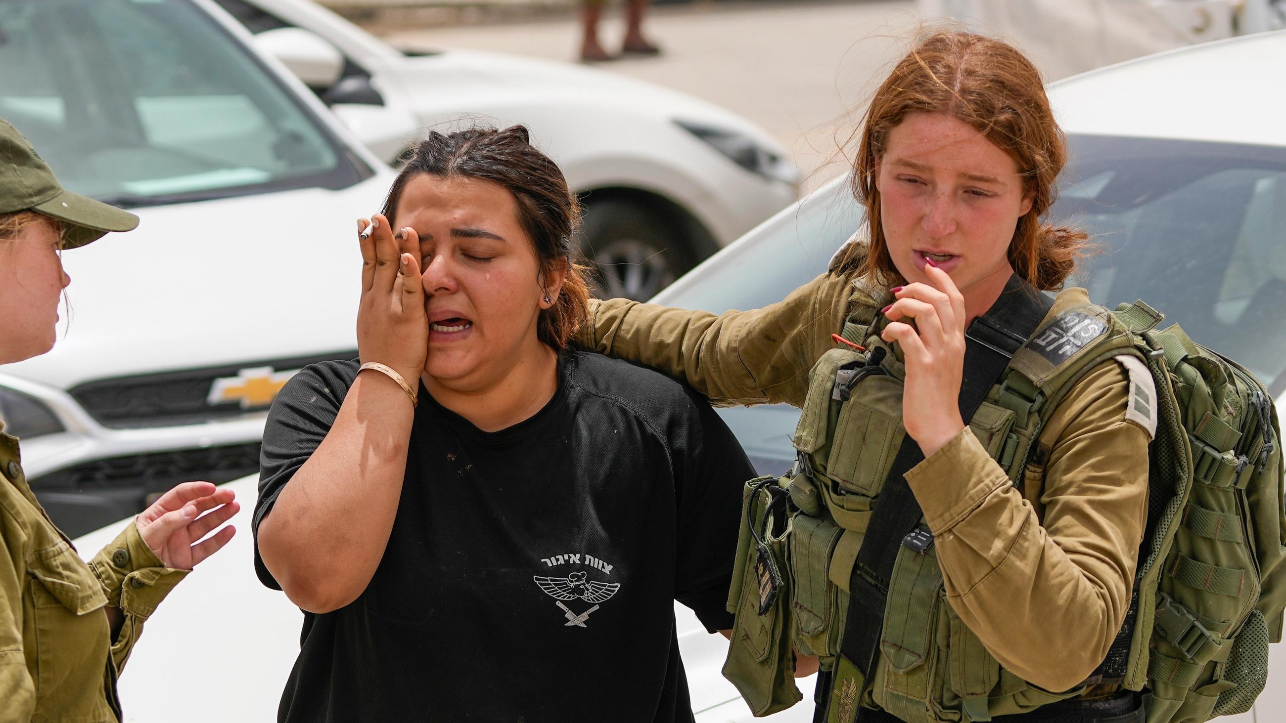 An Israeli soldier cries outside a military base following a deadly shoot-out in southern Israel along the Egyptian border on 3 June 2023 (AP)
