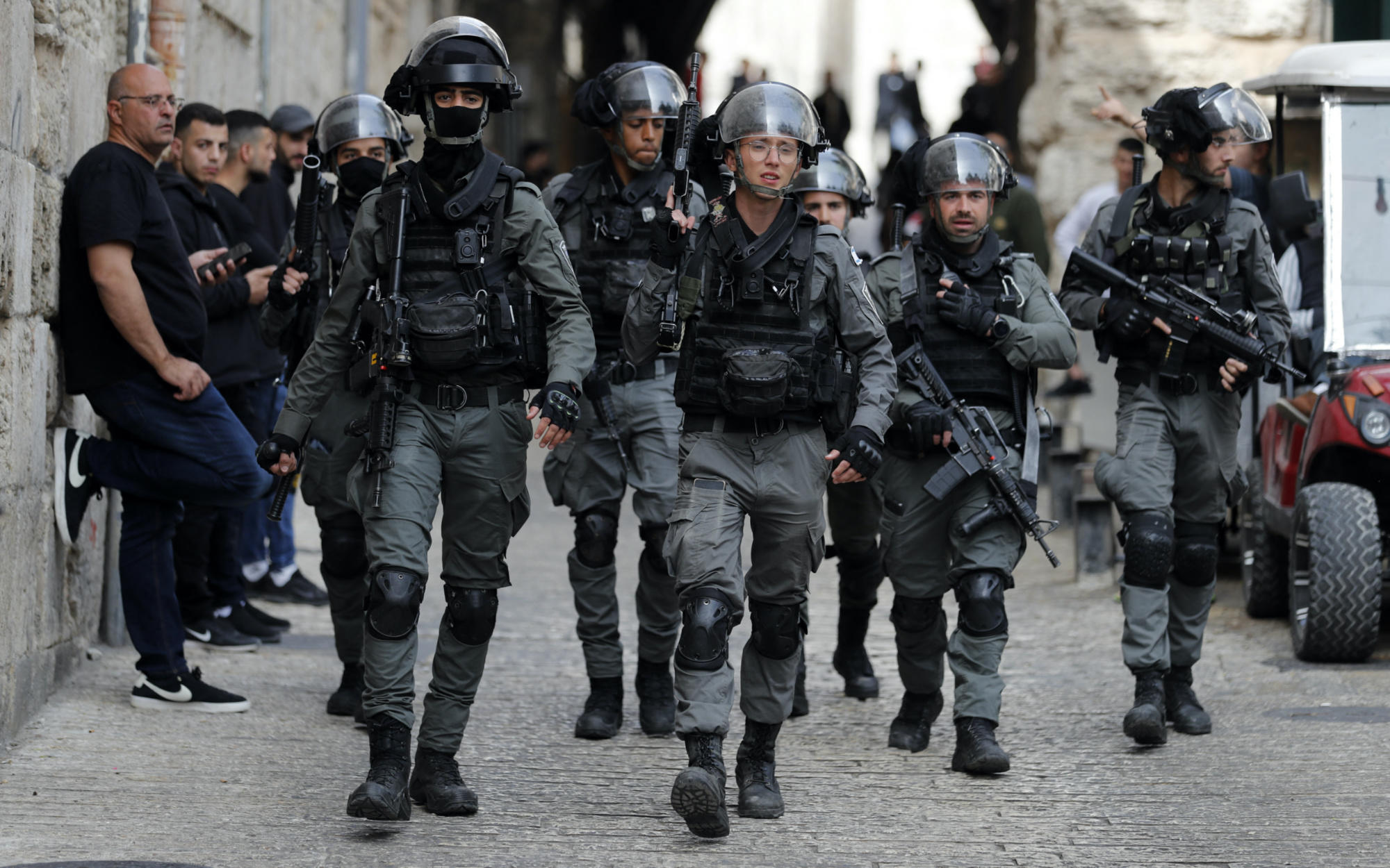 Israeli border police patrol in front of the Lion's Gate in Jerusalem's Old City, as Palestinians wait to be allowed to enter the al-Aqsa Mosque compound, on 17 April 2022 (AFP)