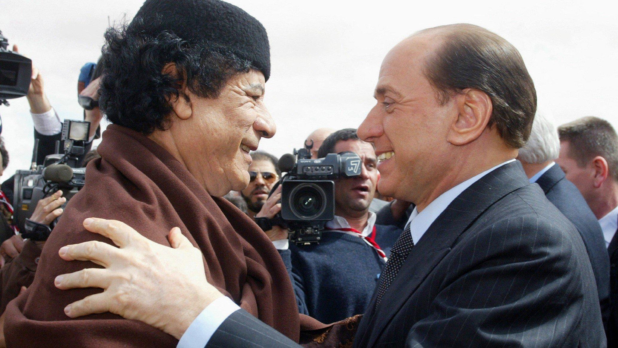Libyan leader Muammar Gaddafi greets Italian Prime Minister Silvio Berlusconi during a meeting in Sirte, Libya on 10 February 2004 (AFP)