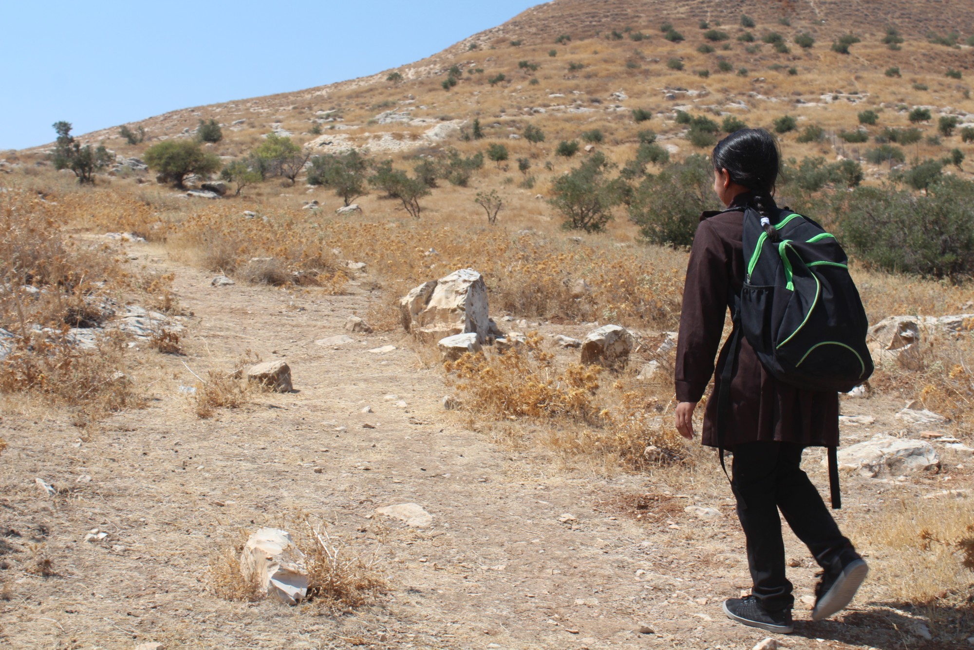 Ibtisam, like many other children in Area C, has to walk on craggy dirt roads to go to school (MEE/Shatha Hammad)