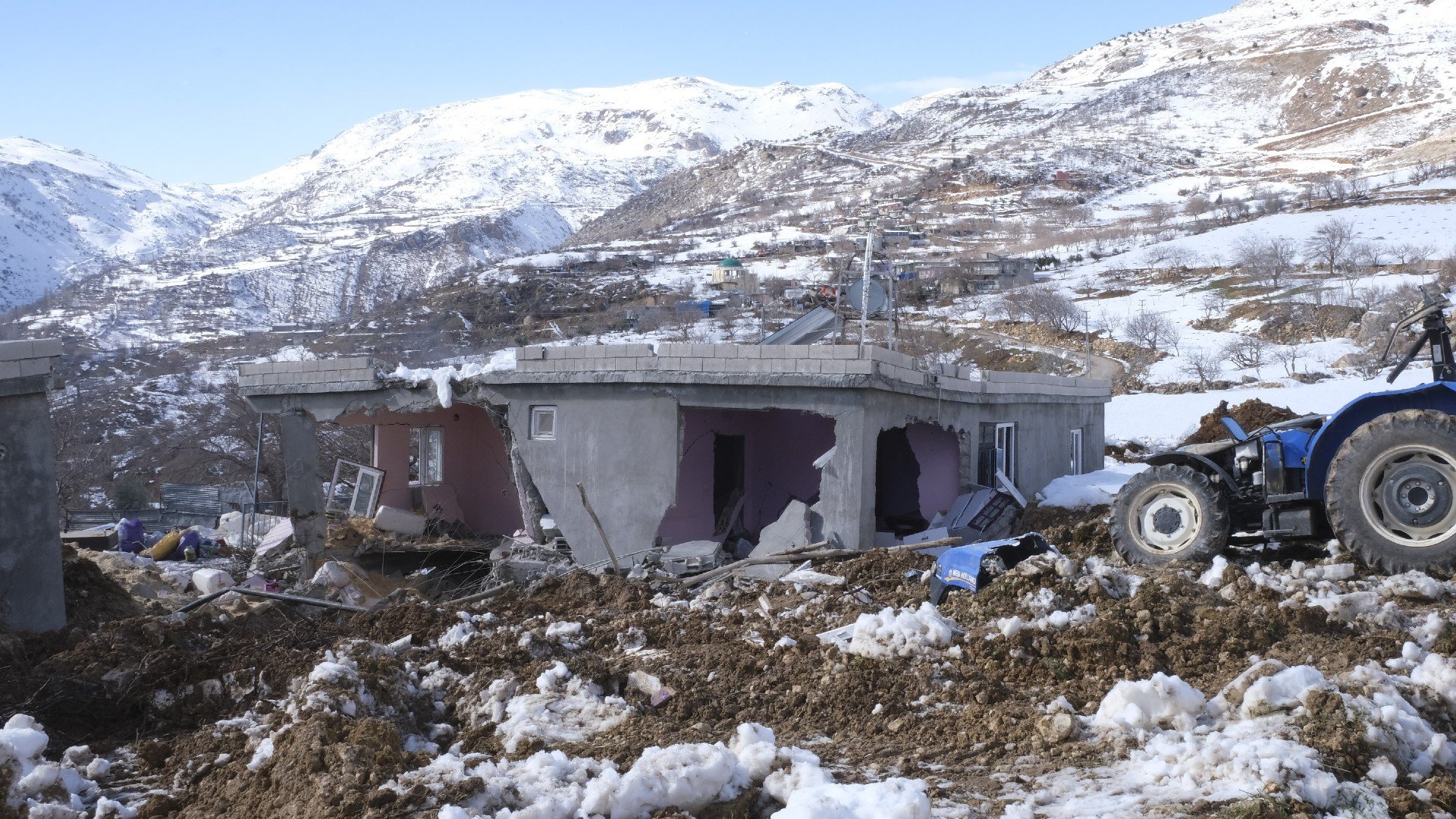 A tractor lies in ruin next to a destroyed building in Pumuklu, a small mountainous village in southern Turkey, on 17 February, 2023 (MEE)